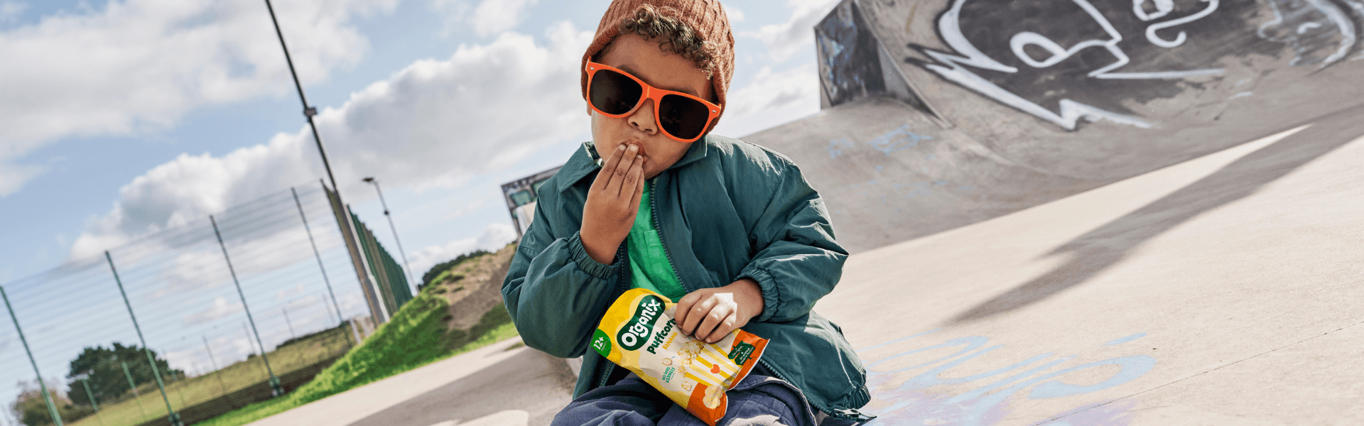 A child enjoying an Organix snack at a skatepark